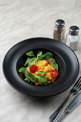 Modern italian cuisine, magno risotto with shrimps in black plate, above view, bright art contrast photo