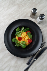 Modern italian cuisine, magno risotto with shrimps in black plate, above view, bright art contrast photo