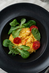 Modern italian cuisine, magno risotto with shrimps in black plate, above view, bright art contrast photo