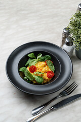 Rich cream mango risotto with prawns, modern fusion cuisine, bright on black, appetizing photo