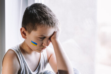 frustrated poor boy protests against the military conflict, cries, worries and is afraid. The...