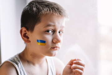 frustrated poor boy protests against the military conflict, cries, worries and is afraid. The...