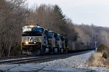 Moving vintage Norfolk Southern cargo train with CPL signals in the background