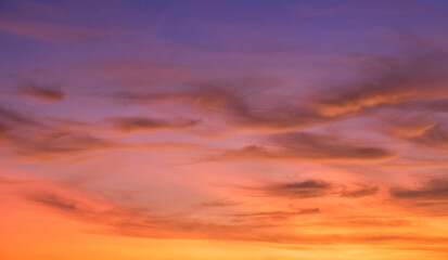 Bunter Sonnenunterganghimmel am Abend mit orangefarbenen, rosafarbenen, purpurroten Sonnenlichtpastellwolken auf goldener Stunde, landschaftlich romantischer Naturhintergrund