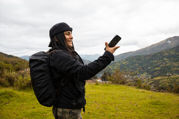 chica con mochila y celular en el paisaje, concepto de viaje,
