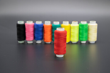 Colorful yarn on spool, yarn on tube, cotton, wool, linen thread, polyester selective focus on red...