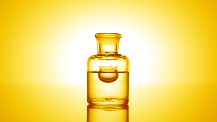 Yellow drop is falls into old fashioned bottle with clear transparent liquid on yellow background and makes crown | Abstract skin care cosmetics with vitamin C formulating concept