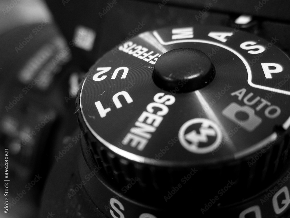 Poster grayscale closeup shot of black camera body with buttons to control and switch shooting modes