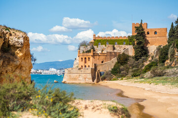 Fototapeta na wymiar Coastline with sandy beach and castle in Ferragudo, Algarve, Portugal