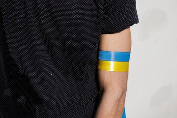 Ukrainian flag color ribbon tied on arm in support of Ukraine.