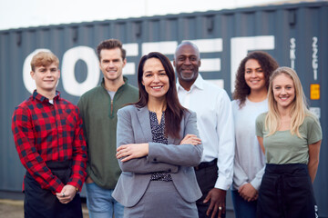 Portrait Of Multi-Cultural Freight Haulage Team Standing By Shipping Container