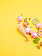 different kinds of Colorful candies isolated on yellow background, top view