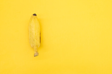 single bananas isolated on yellow background, top view