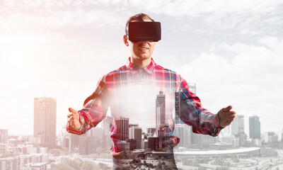 Guy wearing checked shirt and virtual mask stretching hands and trying to concentrate