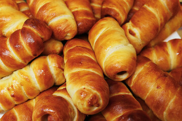 Lot of hotdogs are on platter. Close-up. Top view. Baked sausage in dough. Fresh aromatic pastries. Fast food. background