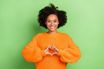 Photo of flirty millennial curly hairdo lady show heart wear orange jumper isolated on green color background