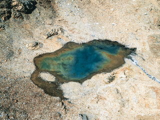 Bird-eye view of a lake surrounded with stones and sand