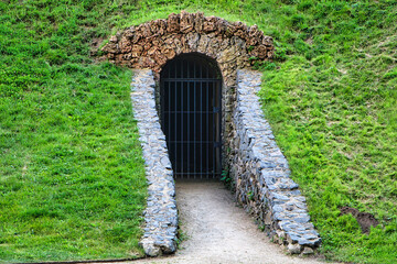 Eingang in zum einen unterirdischen Tunnel mit Gitter davor  