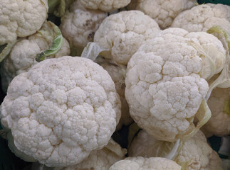 several fresh cauliflowers lie on top of each other.