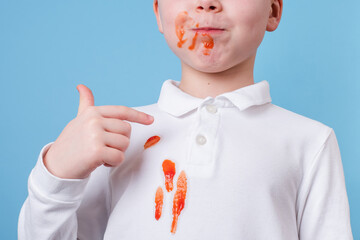 Close up stain tomato sauce spilled on children's outfit. The concept of cleaning stains on clothes