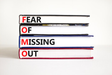 FOMO fear of missing out symbol. Concept words FOMO fear of missing out on books on a beautiful white background. Copy space. Business FOMO fear of missing out concept.