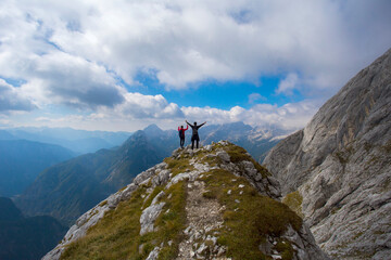 Hikers on hill under Prisojnik peak in Slovenia