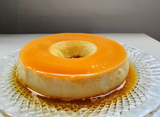  milk pudding with typical Brazilian sweet caramel sauce and wooden background