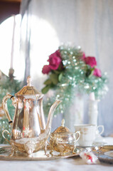 Tea break in English style, vintage silver service against the flowers 