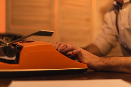 cropped view of writer using typewriter machine.