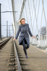 Active woman running across a bridge towards camera