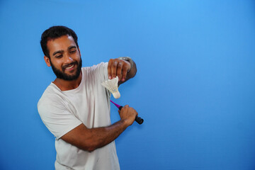 indian male badminton player on blue background.