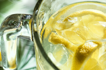 Close up and top view of frozen glass pitcher with lemonade with ice and lemon pieces floating in...