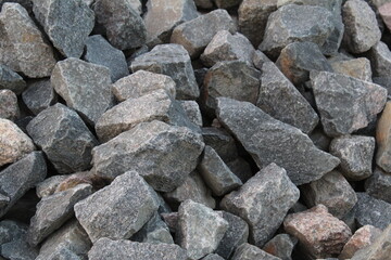 a background of cobblestone stones close-up. stones for the construction of the foundation. Crisis construction of expensive materials