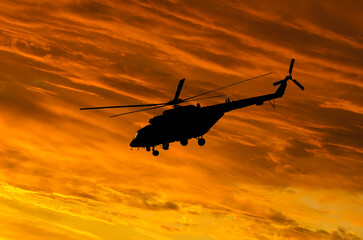 Silhouette of Helicopter on sunset background.