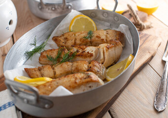 Pan fried pollock fillet with lemon and dill in a roasting pan