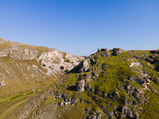 Fototapeta na wymiar Rocks formation in the mountain in the sunny summer day with blue sky on the background.
