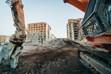 Process of demolition of  building. Excavator breaking old house.