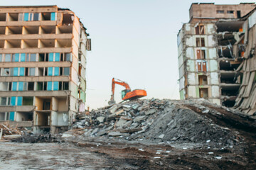 Blurred background of process of demolition of  building. Excavator breaking old house.