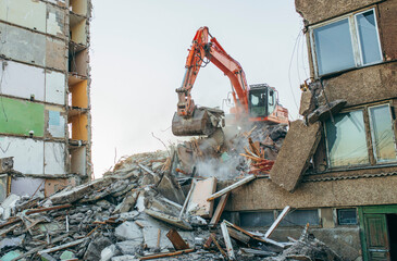 Fototapeta premium Process of demolition of building. Excavator breaking old house.