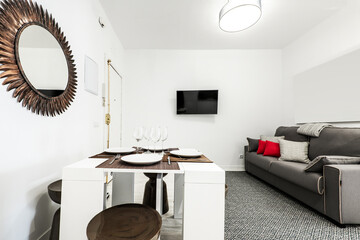 Living room with dining table and three-seater sofa in a vacation rental apartment