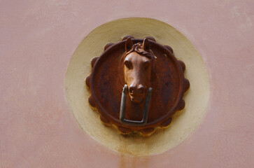 Ancient iron ornament to tie horses or draft animals to the walls of buildings