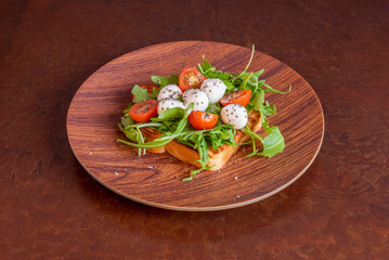 caprese toast. A rich and simple appetizer or hot tapa made with tomato, mozzarella cheese, bread and pesto sauce