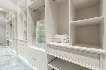 Fototapeta na wymiar Dressing room with shelves, drawers, full-length mirror and blue carpet floor