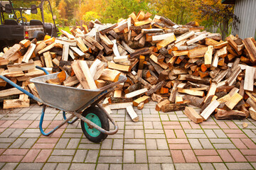 A pile of split firewood for heating a house in the yard.