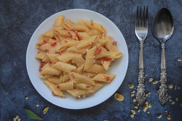 Pasta with cheese and tomatoes in a white plate