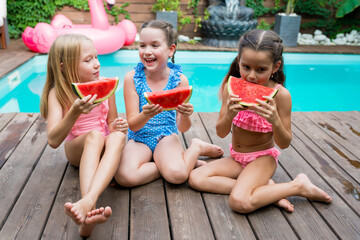 Summertime. Outdoor leisure activity with kids concept. Children eating slices of summer watermelon...
