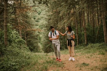 Naklejka premium Couple of hikers with backpacks walk through the forest