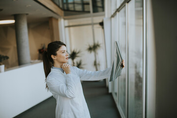 Yyoung female doctos examining x-ray image in the office
