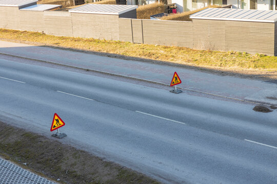 Technological landscape view of an asphalt road with road works sign. Sweden.