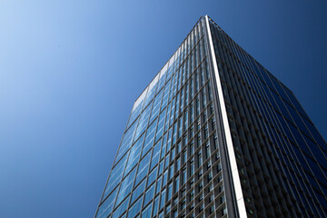 Fototapeta na wymiar Skyscraper. Skyscraper against the blue sky. Glass and metal building, office and business center in a large city.